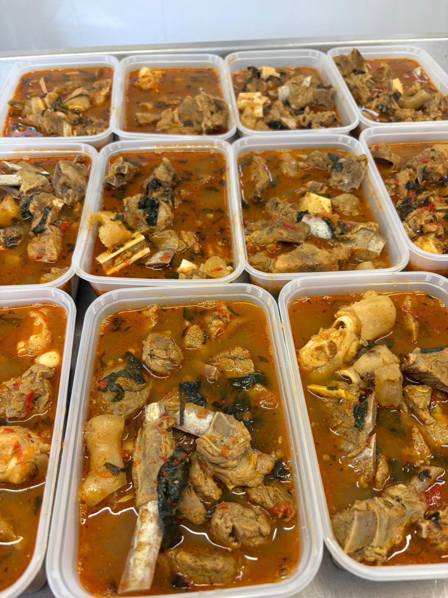 Rows of takeaway tubs filled with mixed goatmeat pepper soup