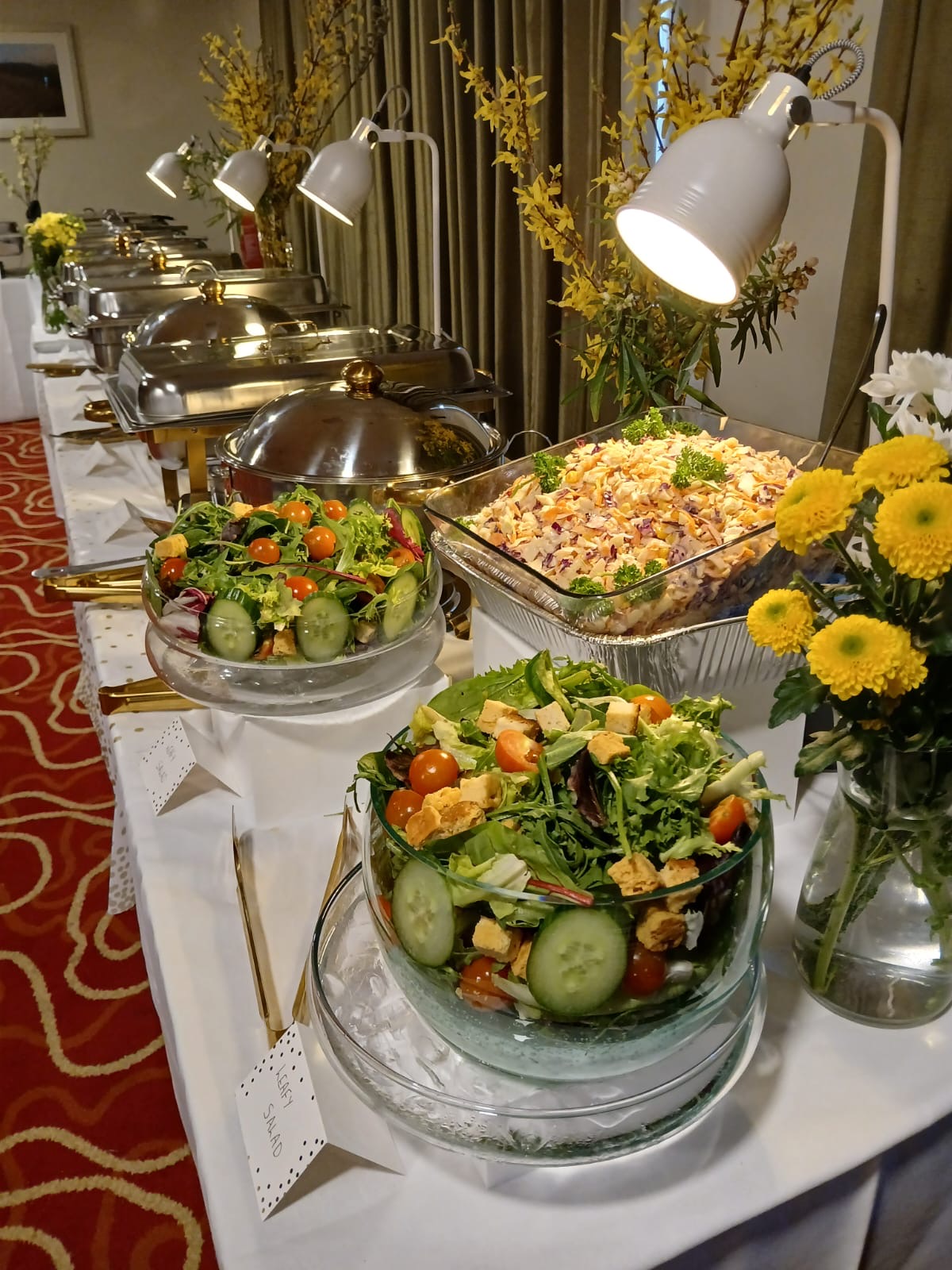 Professionally presented event buffet with fresh salads and hot dishes